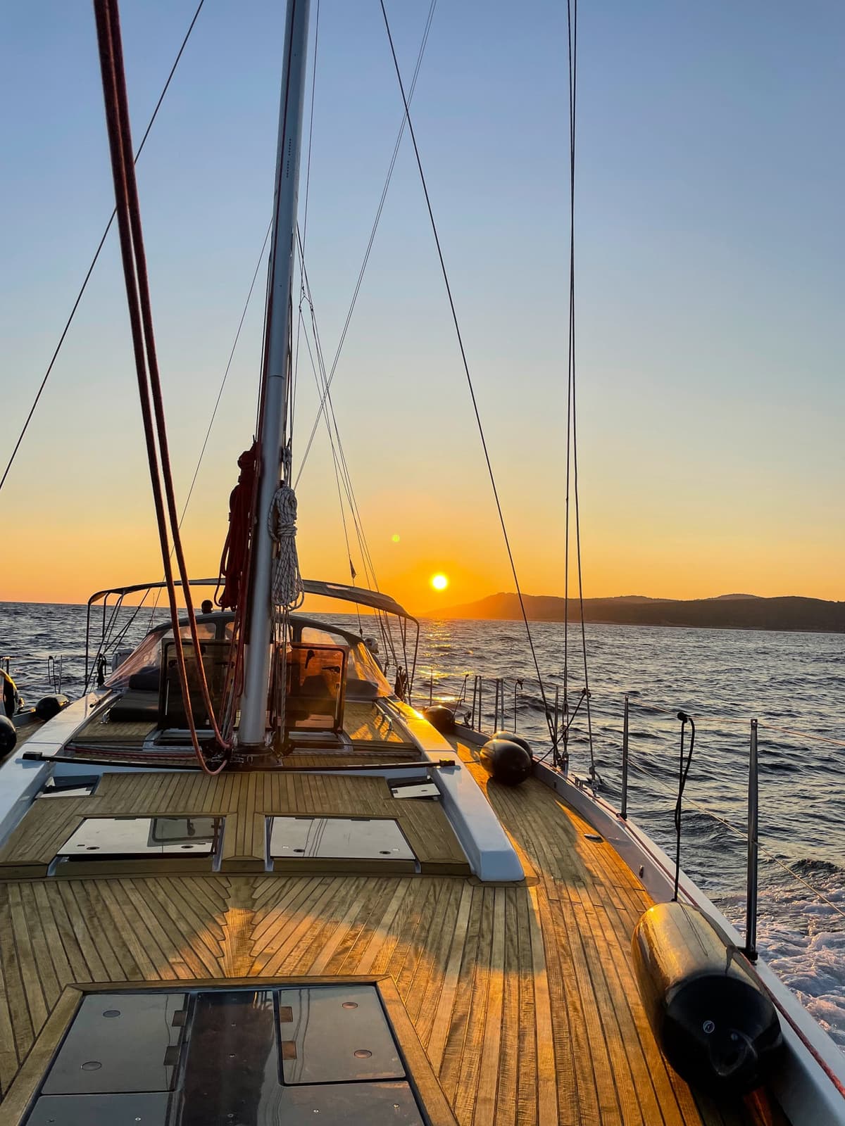 Wooden deck of the sailing yacht at sunset, anchored in a Croatian bay during the Driftawave team retreat.