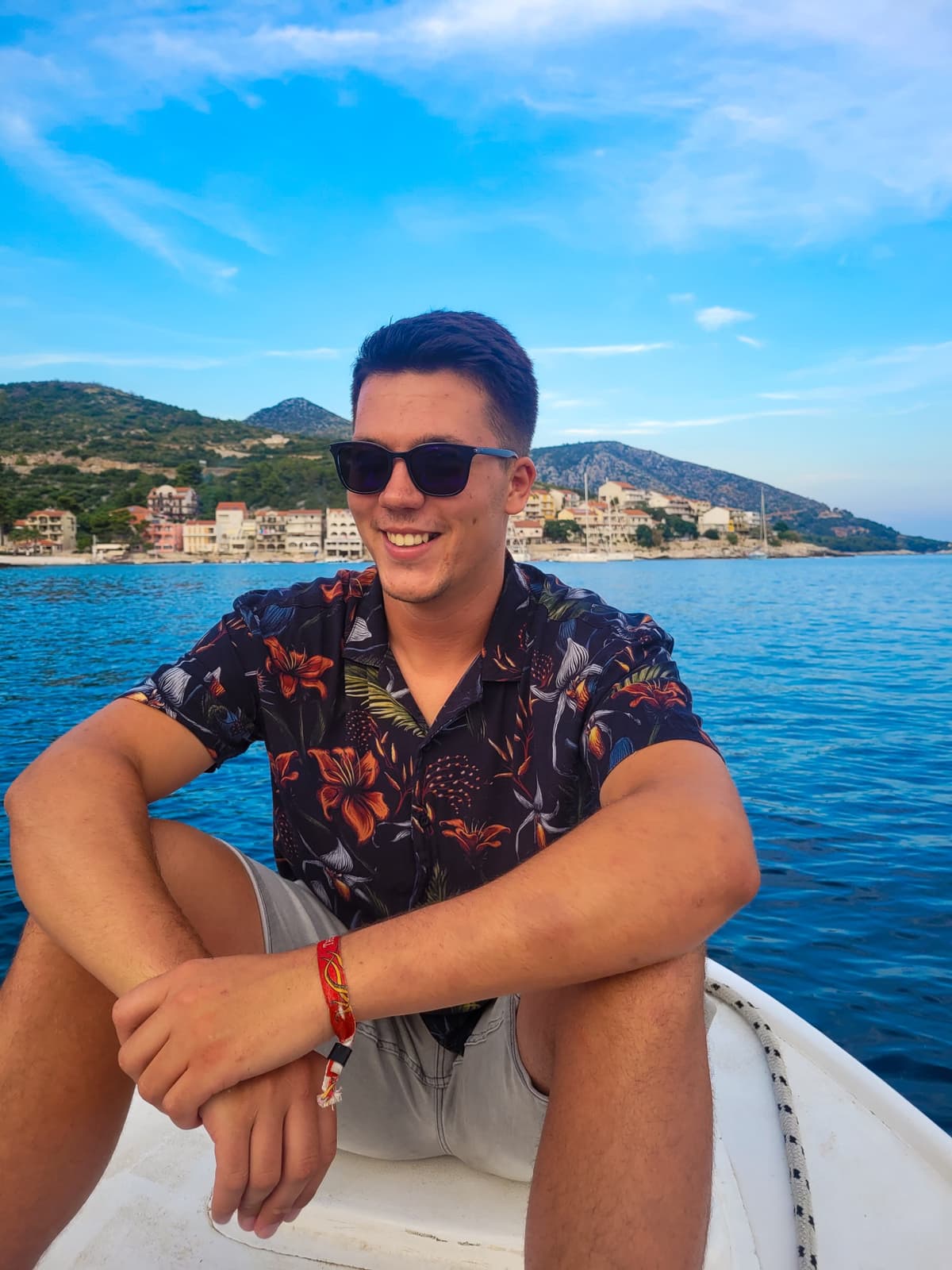 Captain Antonio relaxing on the yacht bow with the Adriatic coast and mountains behind during the Croatia workation.