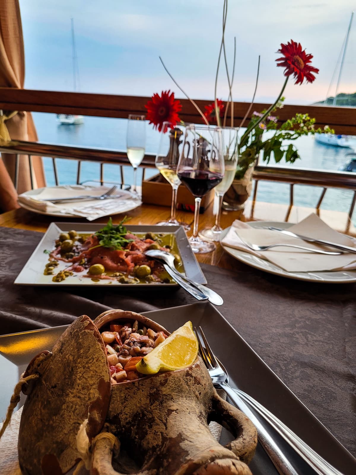 Fresh Croatian seafood platter and wine served at a waterfront restaurant during the Hvar island sailing workation.