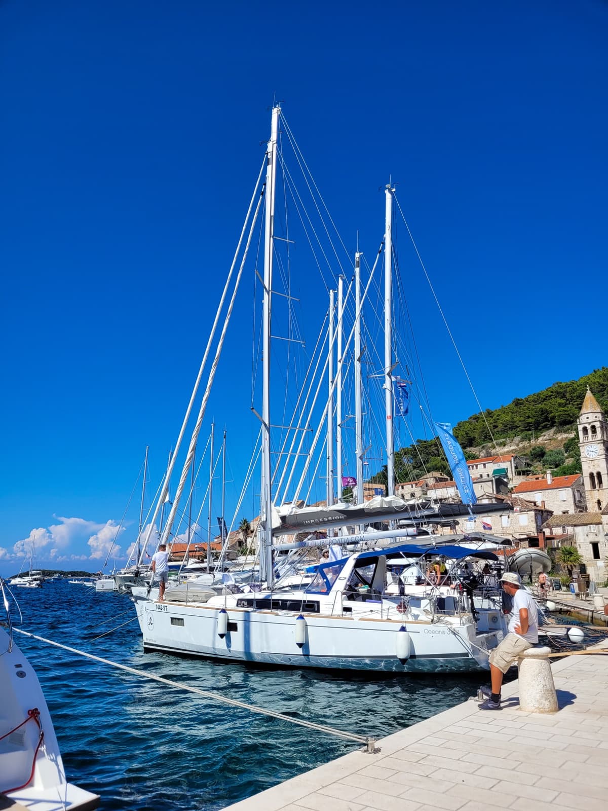 The Hanse 588 sailing yacht docked in Stari Grad marina under a blue sky, ready for team sailing in Croatia.