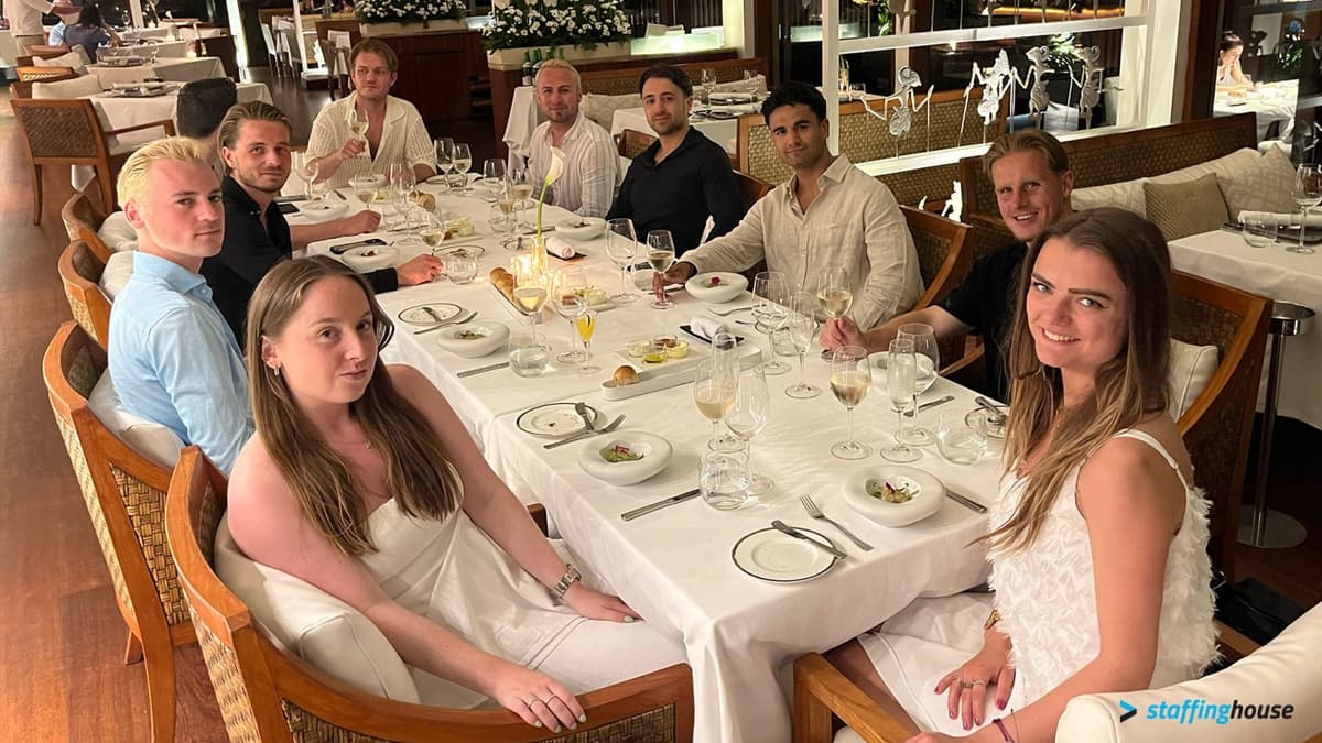 Staffinghouse team celebrating company achievements during a fine dining experience at their Bali workation retreat.