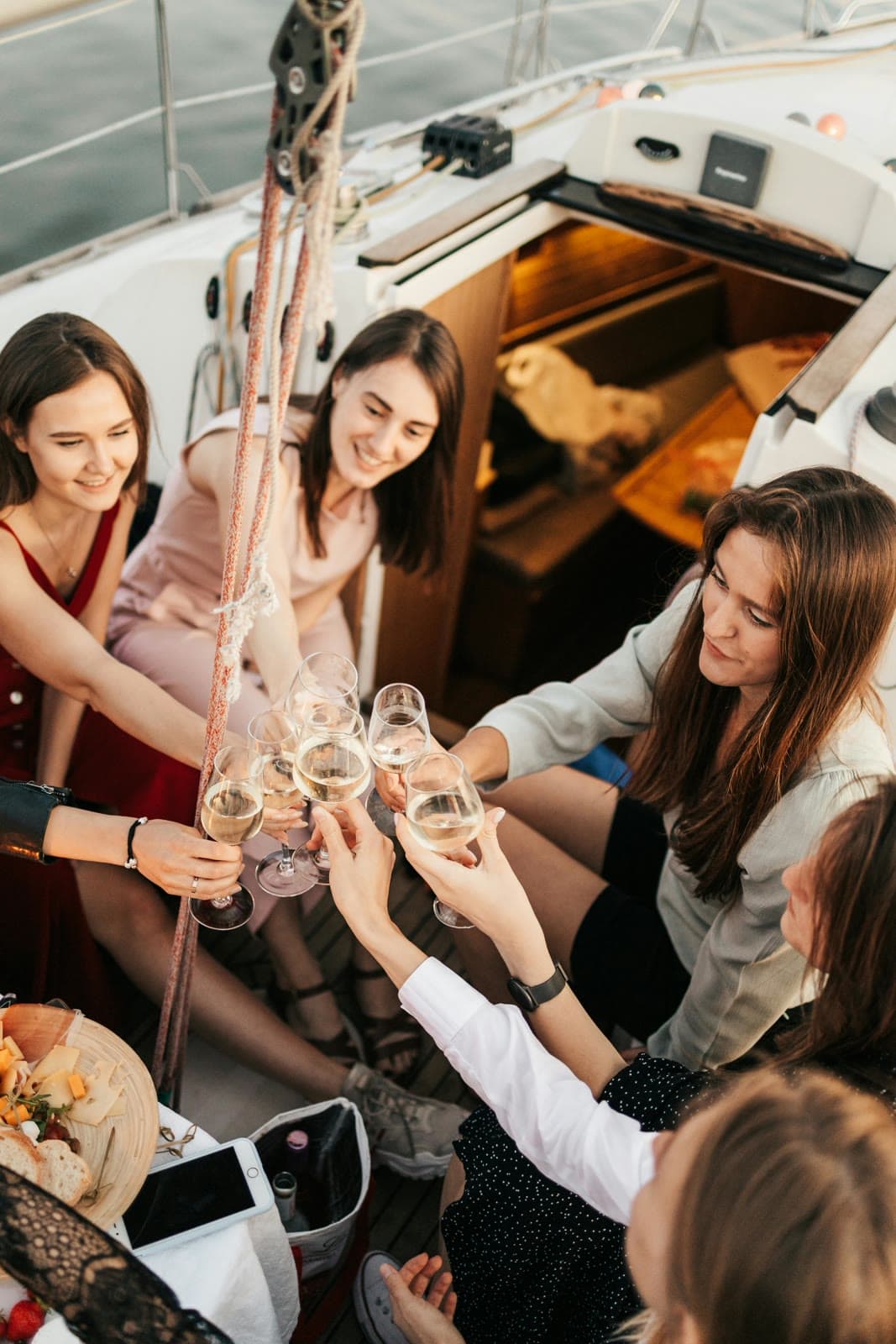 Team members toasting with champagne on a yacht deck during a luxury company retreat celebration.