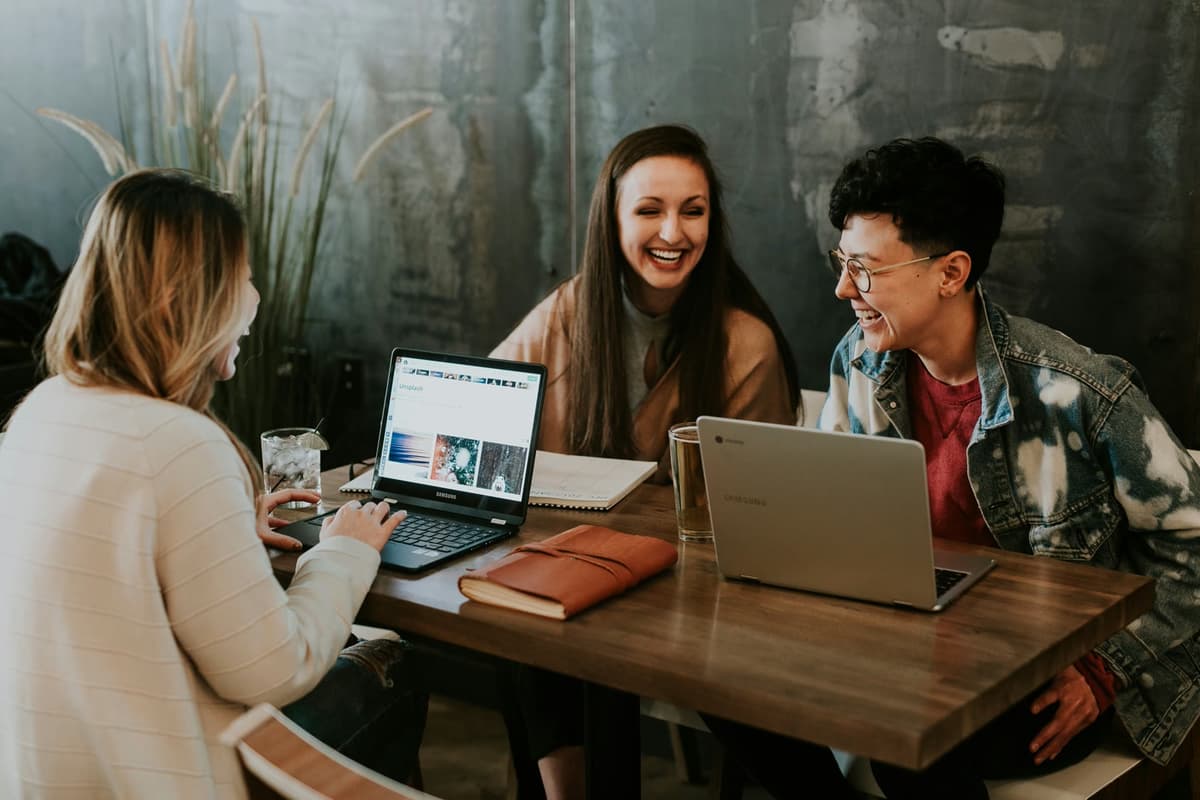 A remote team collaborating on laptops in a modern coworking space during a group workation.