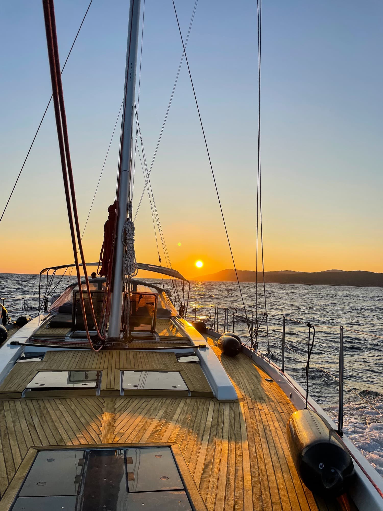 Wooden deck of the sailing yacht at sunset, anchored in a Croatian bay during the Driftawave team retreat.