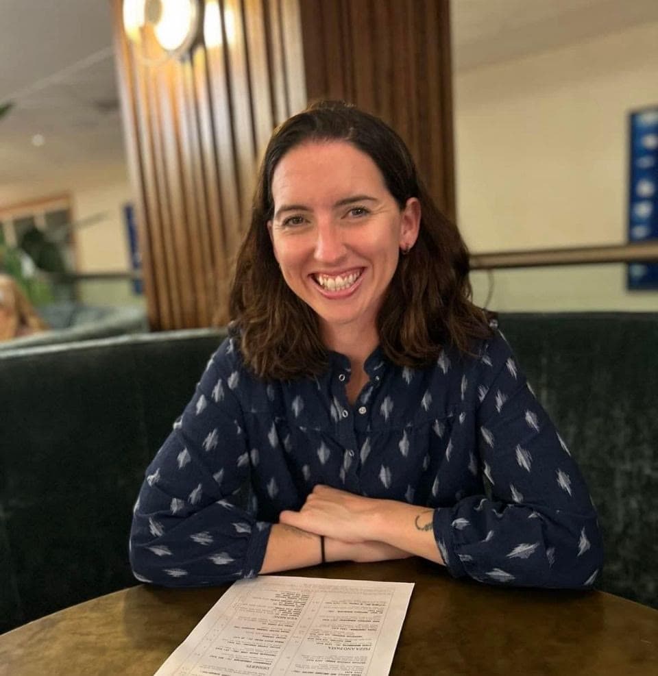 Lara Lain working remotely from a cosy cafe table, balancing productivity and the digital nomad lifestyle during a workation.