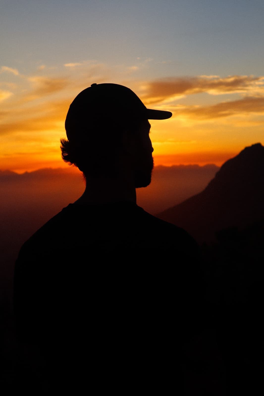 Digital nomad watching the sunset over the mountains at Lions Head in South Africa during remote work travel.
