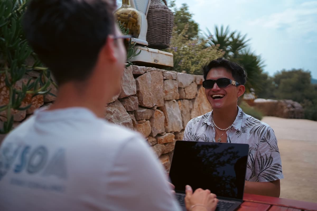 Team bonding moment between colleagues working outdoors during a company workation retreat.