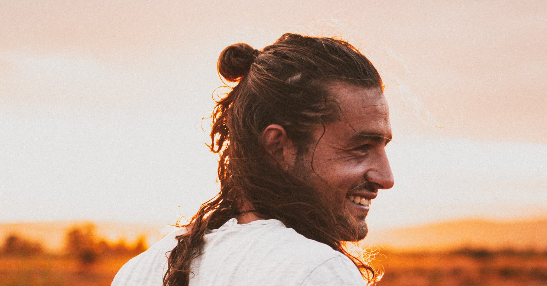 Martijn Smeets, founder of The Thrive Tribe, smiling in a golden Austrian field at sunset, embodying location-independent remote entrepreneurship.
