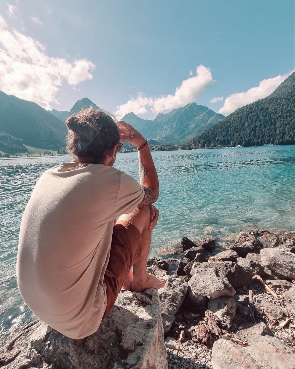 Martijn Smeets seated by an alpine lake in the Austrian Alps, illustrating remote work location flexibility and travel.