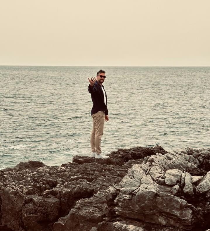 Alex Hernandez, co-founder of Jobgether, standing on coastal rocks, symbolizing the remote work renaissance and entrepreneurial freedom.
