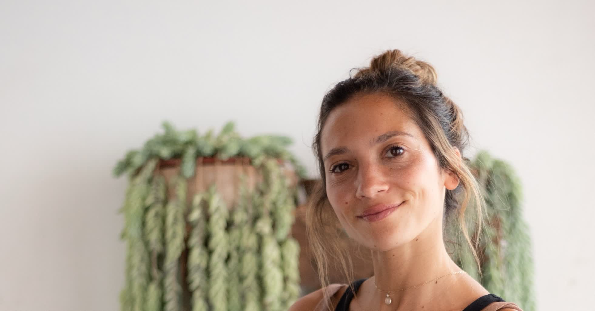 Kristin Vierra, career fulfillment and remote work coach, smiling in her plant filled Buenos Aires space.