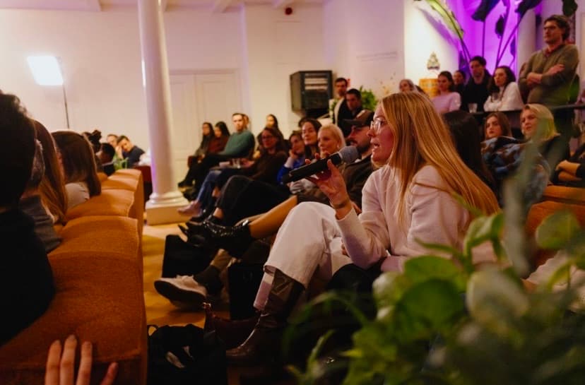 Henny Vogt speaking with a microphone at a remote work industry event.