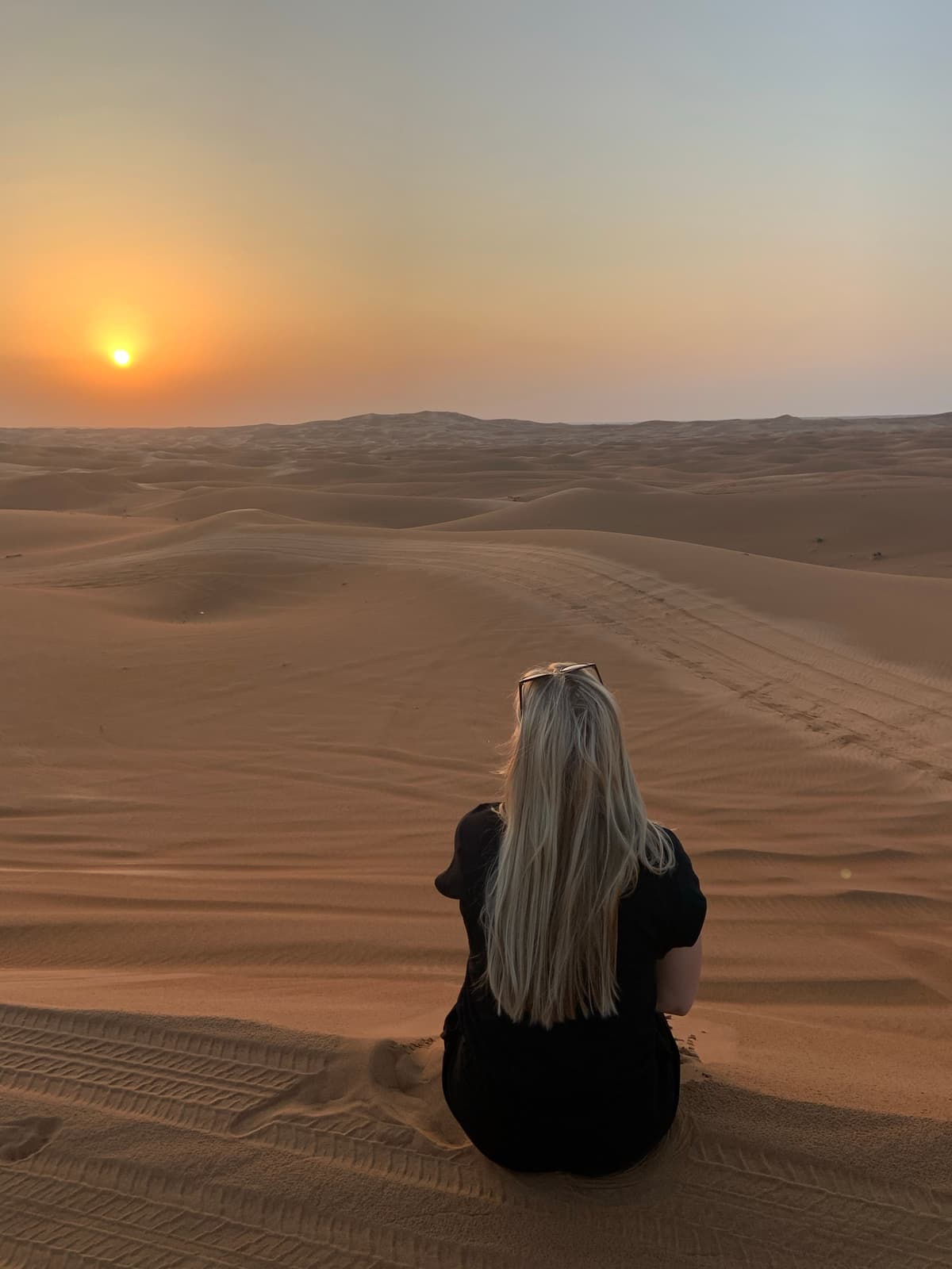 Henny Vogt watching the sunset over desert sand dunes during her remote work travels.