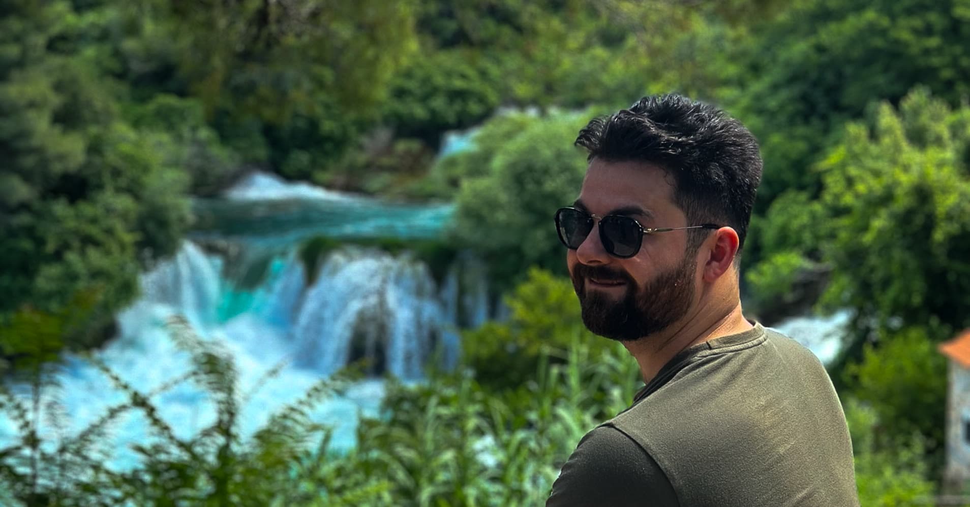 Elia Argentiero at Krka National Park in Croatia, with turquoise waterfalls behind him during a Driftawave sailing workation.