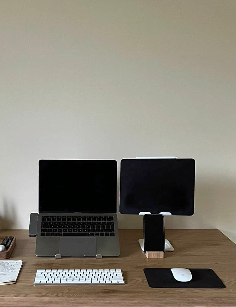 A productive remote work desk setup featuring a MacBook Pro with an iPad Air as a second monitor for a digital nomad workflow.