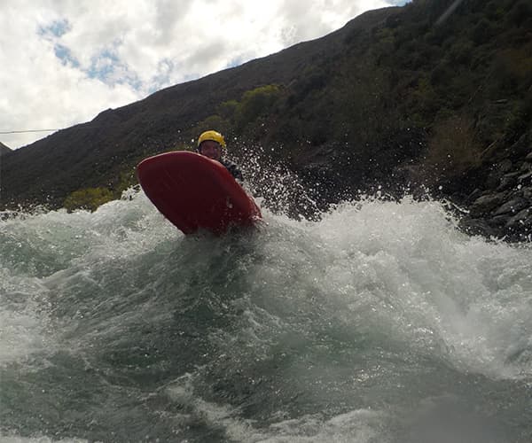 River boarding through white water in New Zealand, adrenaline teambuilding on a company offsite