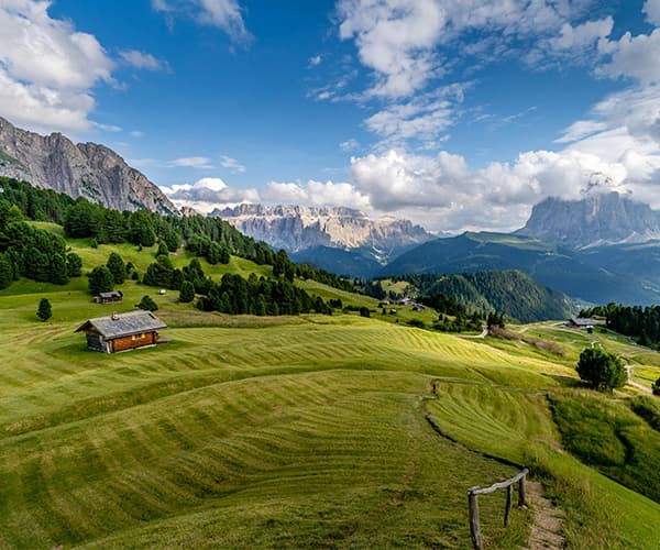 Alpine meadow with cabin and Dolomite peaks for mountain retreat in South Tyrol Italy