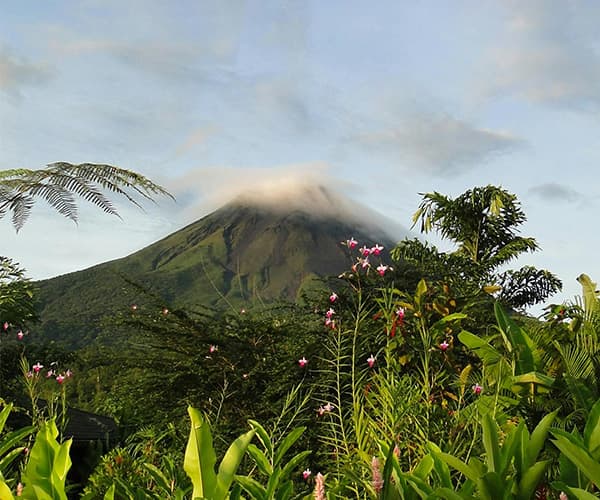 Arenal Volcano with cloud cap and tropical jungle for mountain retreat in Costa Rica