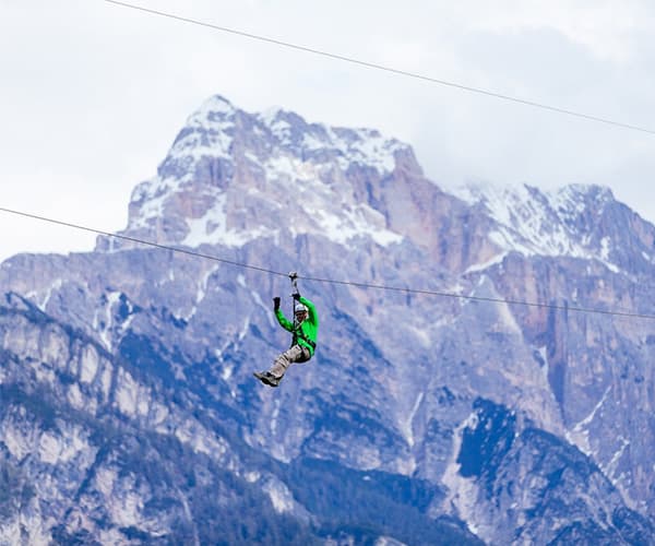 Team building zipline over alpine mountains during adventure offsite in Austrian Alps