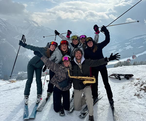 Team offsite celebrating on ski slopes during winter team retreat in Austrian Alps