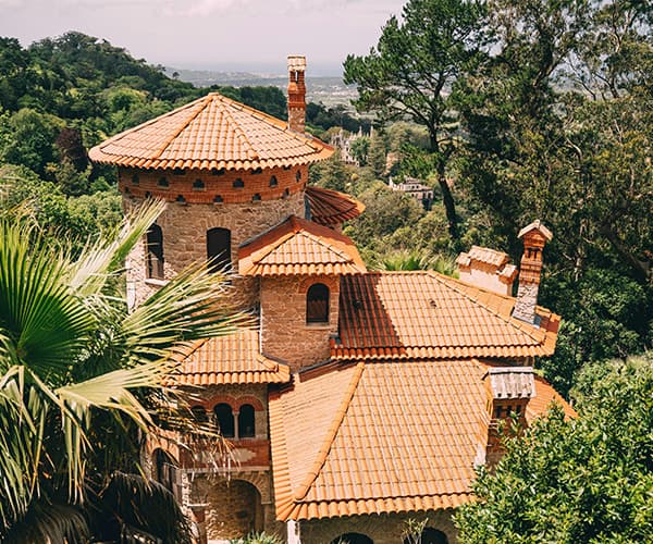 A Mediterranean stone villa and its tower rising out of the forest, private venue for a company offsite