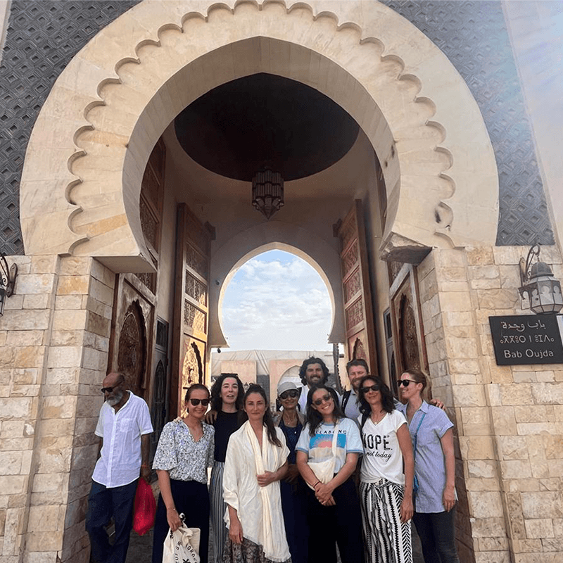 A remote team gathered under a Moroccan gateway, culture day on a Driftawave workation