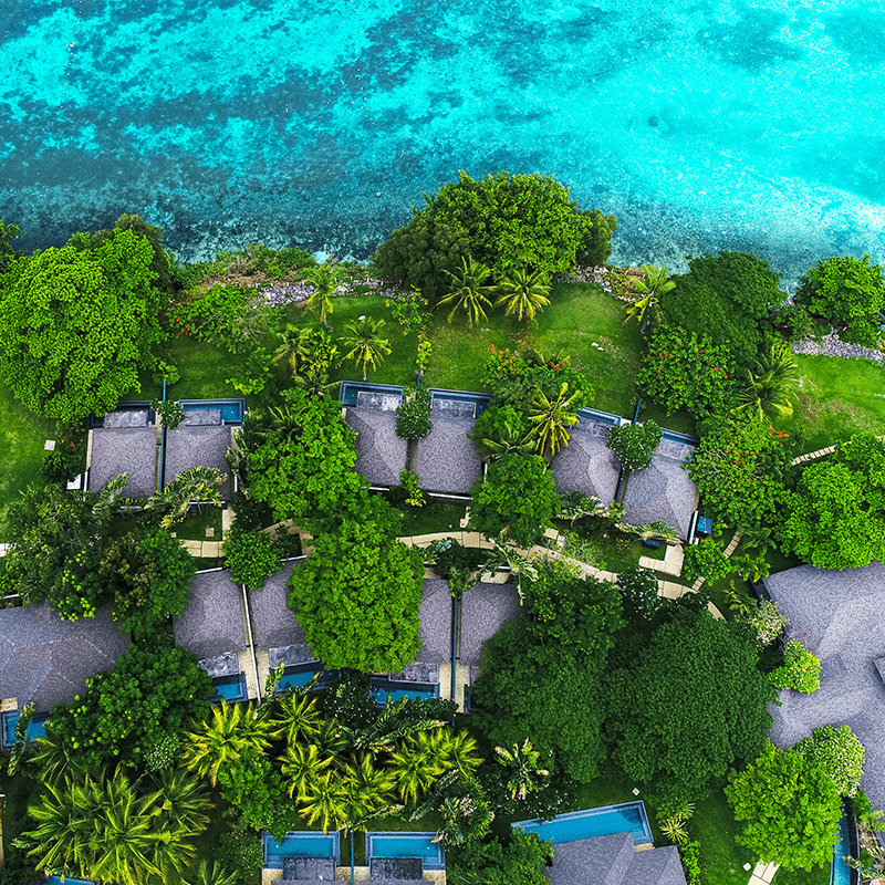 Aerial view of beachfront villas with private pools for executive innovation retreat in Philippines
