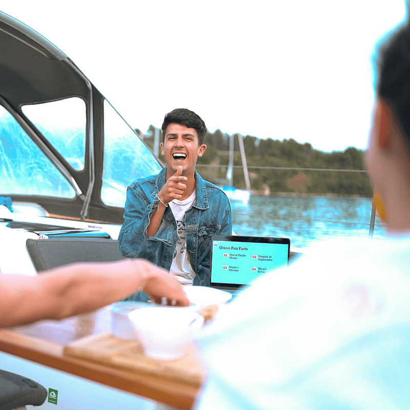 A growth marketing team working on deck, sailing workation with an ocean sustainability session