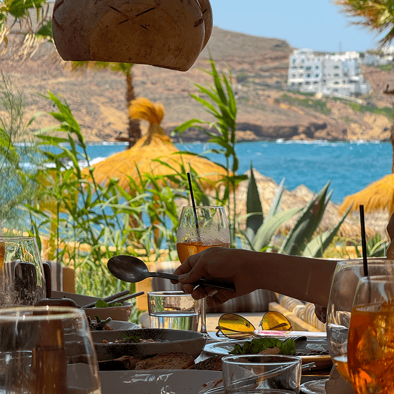 Plating dinner with the Greek coast behind, food as part of a marketing company offsite