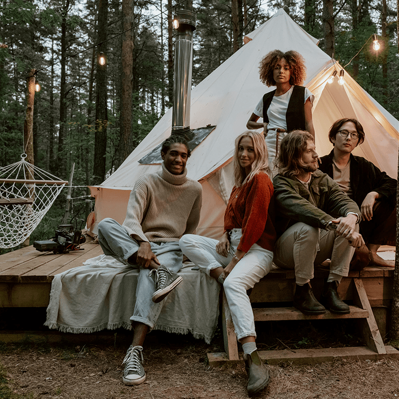 A marketing team on the deck of a bell tent in the woods, glamping team retreat