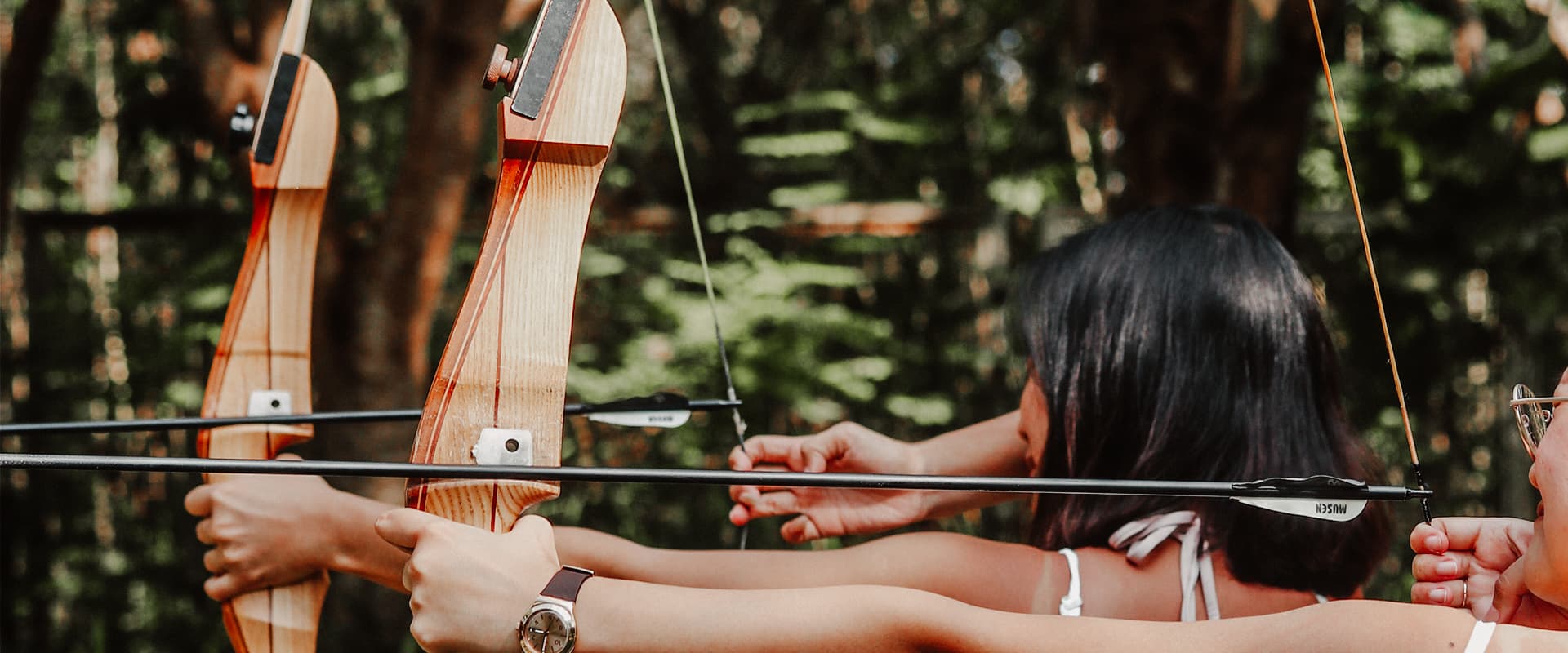 Team member aiming bow and arrow during strategic communication retreat representing focused messaging and precision storytelling
