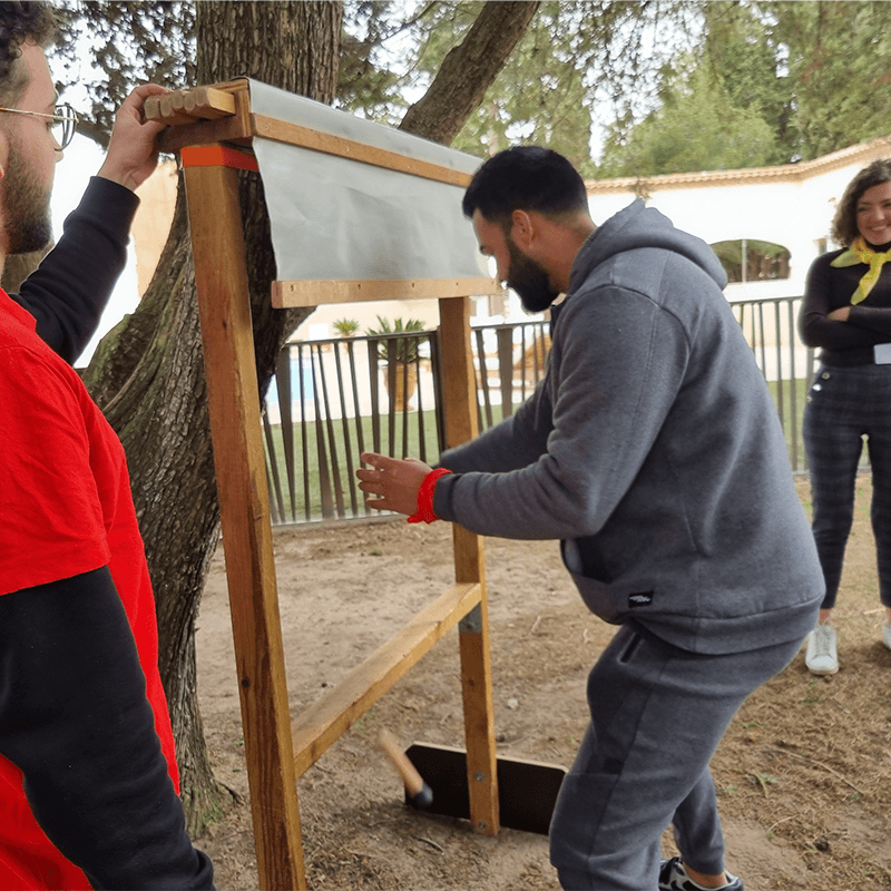 Two team members building a frame together, collaboration challenge on an outdoor company offsite